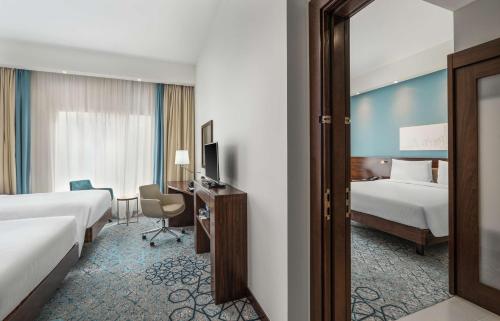 迪拜Hampton By Hilton Dubai Al Barsha的酒店客房,设有两张床和镜子