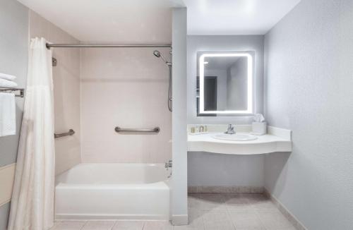 纽瓦克DoubleTree by Hilton Newark Penn Station, NJ的带淋浴和盥洗盆的白色浴室