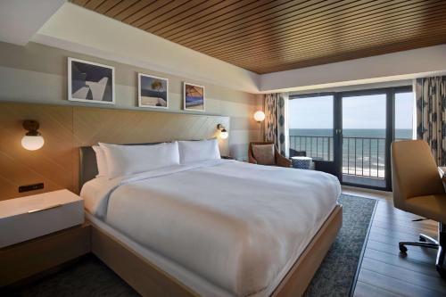弗吉尼亚海滩DoubleTree by Hilton Oceanfront Virginia Beach的酒店客房设有一张大床和一个阳台。