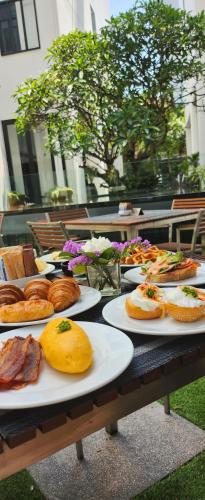 曼谷曼谷素坤逸 15 号瑞享酒店的一张桌子,上面放有面包和糕点盘