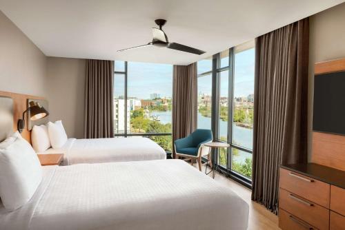 威尔明顿Homewood Suites By Hilton Wilmington Downtown的酒店客房设有两张床和大窗户。