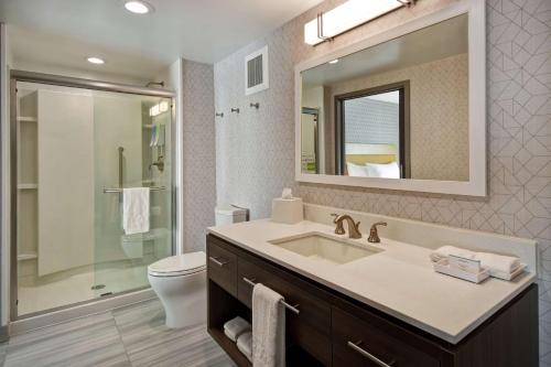 泰勒Home2 Suites By Hilton Taylor Detroit的一间带水槽、卫生间和镜子的浴室