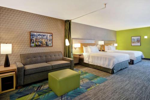 泰勒Home2 Suites By Hilton Taylor Detroit的酒店客房,设有两张床和一张沙发