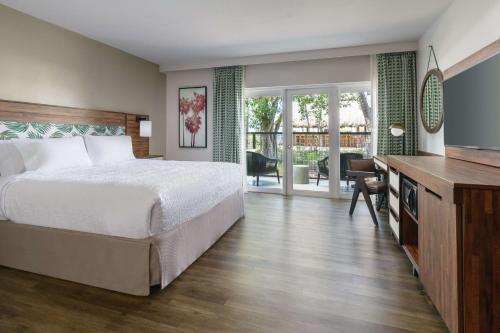 基韦斯特Hampton Inn Key West FL的一间卧室配有一张床和一张书桌及电视