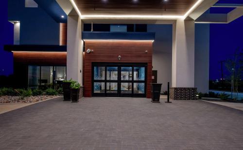 邓肯维尔Hampton Inn & Suites Duncanville Dallas, Tx的一座在晚上有大玻璃门的建筑