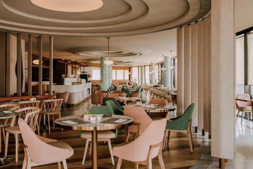 斯维诺乌伊希切Hilton Swinoujscie Resort And Spa的一间带桌椅和天花板的餐厅