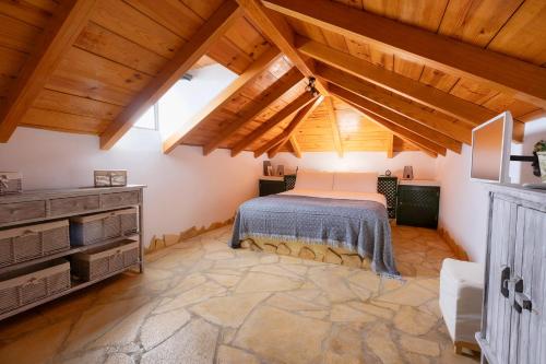 ArafoMountain Getaway for Hikers 1的一间带一张床的卧室,位于带木制天花板的房间内