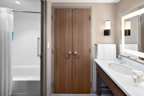沃本Homewood Suites by Hilton Boston Woburn的一间带水槽和木门的浴室