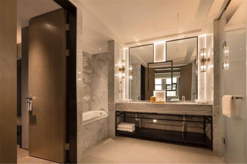徐州徐州云龙希尔顿花园酒店的一间带水槽、浴缸和镜子的浴室