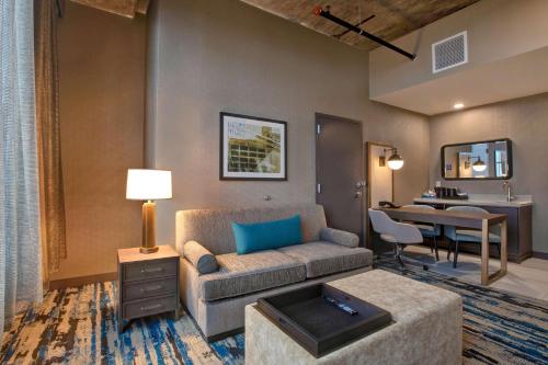 罗克福德Embassy Suites By Hilton Rockford Riverfront的客厅配有沙发和桌子