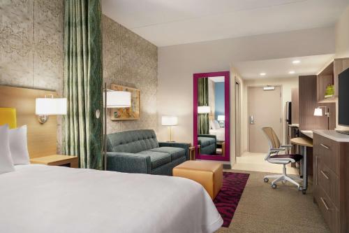 格伦米尔斯Home2 Suites By Hilton Glen Mills Chadds Ford的配有一张床和一张书桌的酒店客房