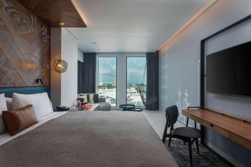 坎昆Canopy By Hilton Cancun La Isla的酒店客房设有电视和客厅。