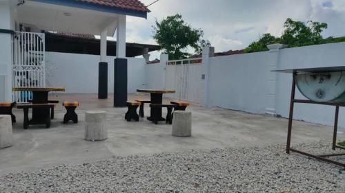 Kampong Baharu CheratingGarlic Cherating Pool Homestay的庭院里的一组桌子和长椅