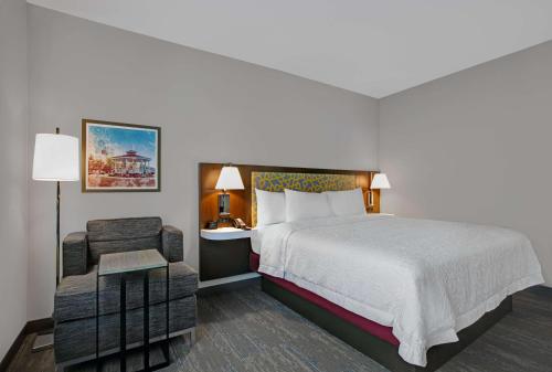 法默斯布兰奇Hampton Inn & Suites Farmers Branch Dallas, Tx的配有一张床和一把椅子的酒店客房