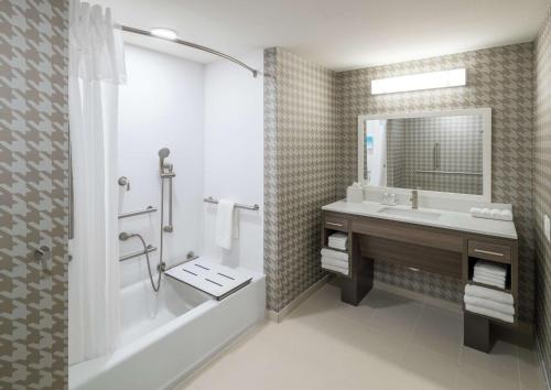 杰克逊维尔Home2 Suites By Hilton Jacksonville Airport的带浴缸、水槽和淋浴的浴室