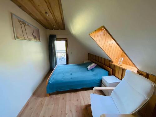 GratiÅ¡kÄ—sForest springs. Family vacation tennis beach sauna的一间卧室配有蓝色的床和椅子