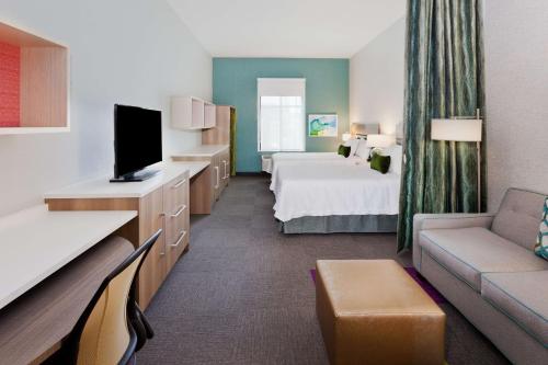 阿尔法利塔Home2 Suites By Hilton Alpharetta, Ga的酒店客房,配有床和沙发
