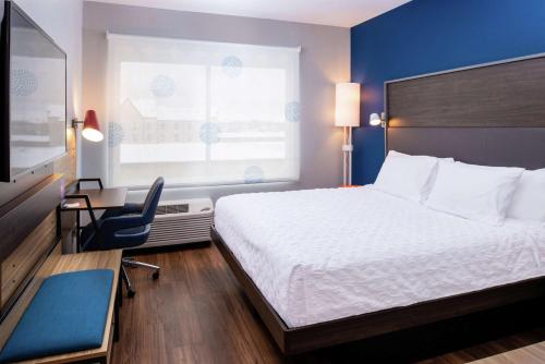 埃尔克哈特Tru By Hilton Elkhart, In的配有一张床、一张书桌和一扇窗户的酒店客房