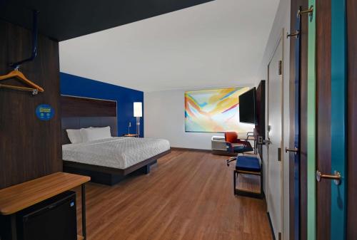 门罗Tru By Hilton Monroe, MI的一间卧室配有一张床和一台电视。
