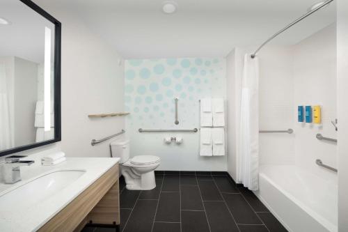奥兰多Tru By Hilton Orlando Convention Center的浴室配有卫生间、浴缸和水槽。