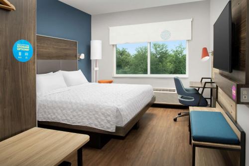 奥兰多Tru By Hilton Orlando Convention Center的酒店的客房 - 带一张床、椅子和窗户
