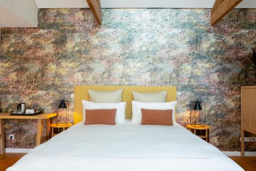 昂蒂布法布里特别墅的卧室配有白色床和色彩缤纷的墙壁