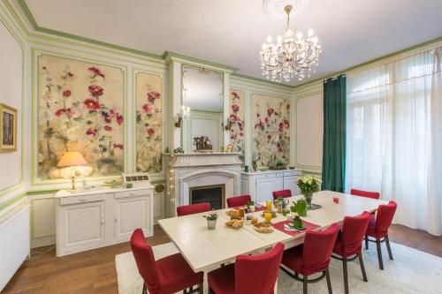 阿杜尔河畔艾尔"Le Jardin sur l'Eau "chambres d'hôtes et appartement tout confort的一间带桌椅和壁炉的用餐室