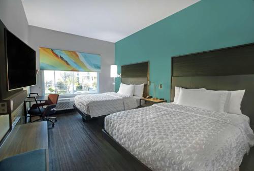 奥斯汀Tru By Hilton Austin Airport, Tx的酒店客房设有两张床和窗户。