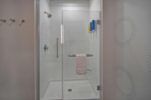 西孟菲斯Tru By Hilton West Memphis, Ar的一个带玻璃门和水槽的淋浴