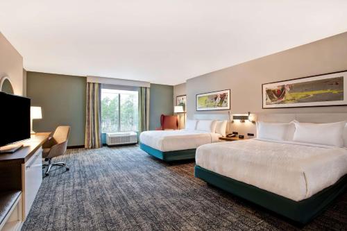 萨默维尔Hilton Garden Inn Summerville, Sc的酒店客房设有两张床和一台平面电视。