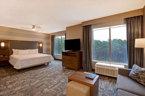 萨默维尔Homewood Suites By Hilton Summerville的酒店客房设有一张床和一个大窗户