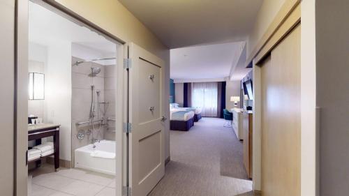安纳海姆SunCoast Hotel Anaheim, Tapestry Collection by Hilton的客房设有带浴缸的浴室和一张床
