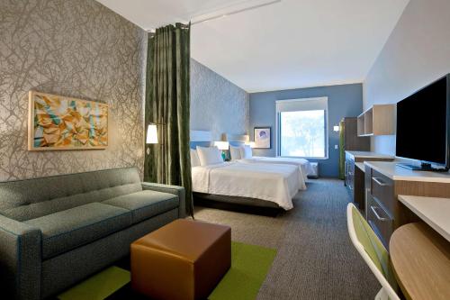 路易斯维尔Home2 Suites By Hilton Lewisville Dallas的酒店客房,配有床和沙发