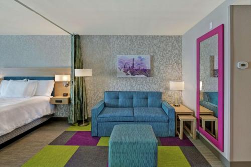 巴克艾Home2 Suites By Hilton Buckeye Phoenix的酒店客房,配有一张床和一张蓝色椅子