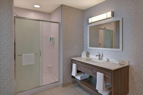 巴克艾Home2 Suites By Hilton Buckeye Phoenix的浴室配有盥洗盆和带镜子的淋浴