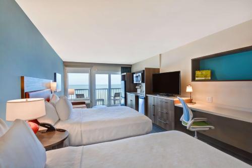 奥蒙德海滩Home2 Suites Ormond Beach Oceanfront, FL的酒店客房设有两张床和一台平面电视。
