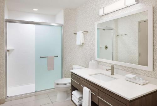 斯图尔特Home2 Suites By Hilton Stuart的一间带水槽、卫生间和镜子的浴室