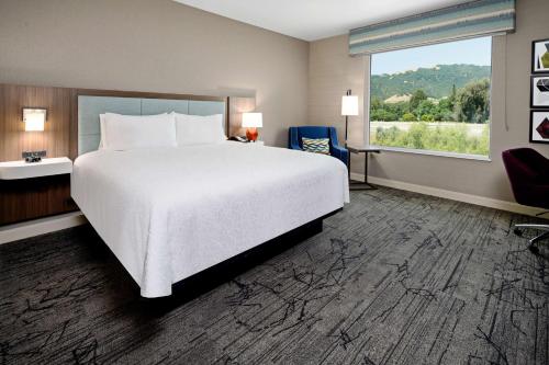 吉尔罗伊Hampton Inn & Suites Gilroy, Ca的一间设有大床和窗户的酒店客房