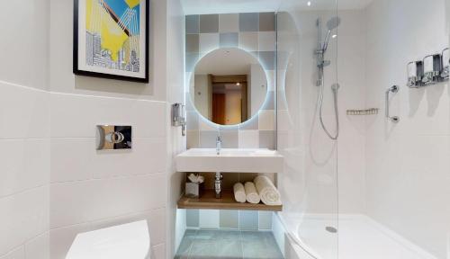 曼彻斯特Hampton By Hilton Manchester Northern Quarter的一间带水槽、淋浴和镜子的浴室