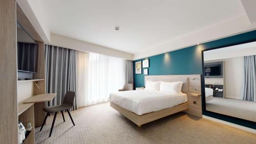 曼彻斯特Hampton By Hilton Manchester Northern Quarter的酒店客房设有一张床和一面大镜子