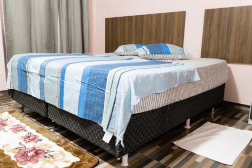 波多韦柳Guajará Palace Hotel的一间卧室配有一张带蓝白色毯子的床