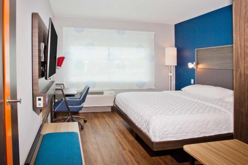 普拉特维尔Tru By Hilton Prattville的酒店客房设有一张床、一张书桌和一台电视机。