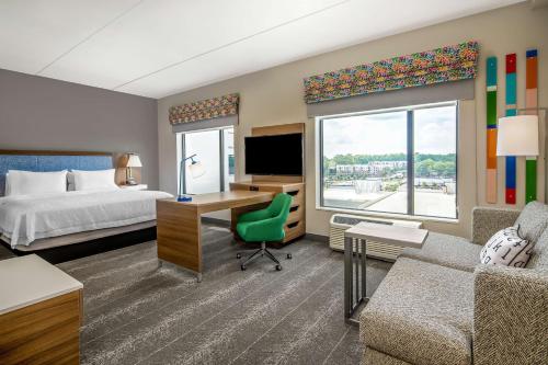 罗利Hampton Inn & Suites Raleigh Midtown, NC的酒店客房配有一张床和一张带电脑的书桌
