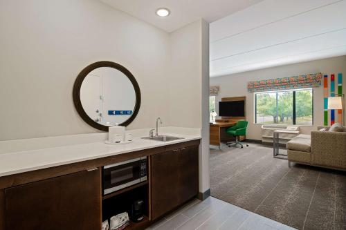 罗利Hampton Inn & Suites Raleigh Midtown, NC的客房内的浴室设有水槽和镜子