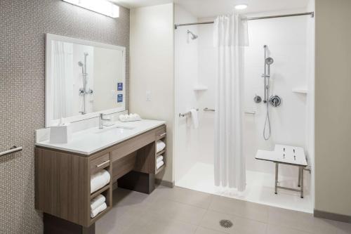 卡纳维拉尔角Home2 Suites By Hilton Cape Canaveral Cruise Port的一间带水槽和淋浴的浴室