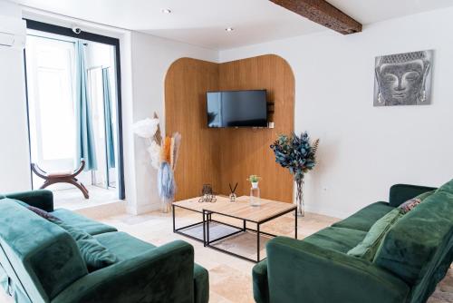 卡尔卡松**Auberge de l'Aude**的客厅配有两张绿色沙发和一张桌子