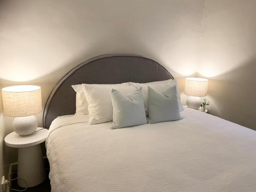 AngastonAngaston Mews Apartments的一张带白色枕头的床和两盏灯