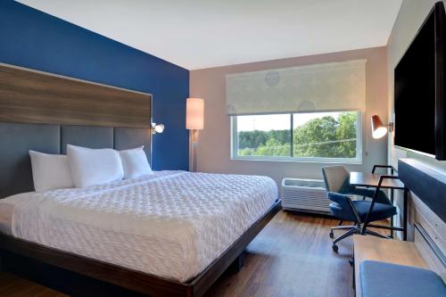 米尔堡Tru By Hilton Fort Mill, Sc的配有一张床、一张书桌和一扇窗户的酒店客房