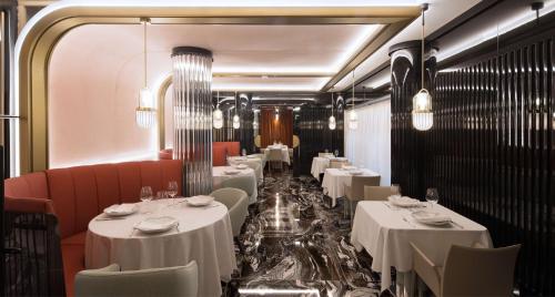 拉科鲁尼亚DoubleTree By Hilton A Coruña的用餐室配有白色的桌子和红色的椅子