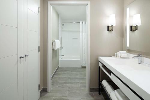 蒙特利尔Homewood Suites By Hilton Montreal Midtown的带淋浴和盥洗盆的白色浴室